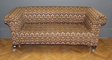 A Chesterfield style settee with later cover, raised on turned legs and castors, width 185cm