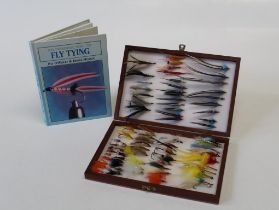 A cased collection of approximately sixty-seven 20th century salmon and trout fishing flies,