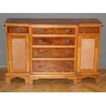 A reproduction breakfront yew veneer credenza, fitted six drawers and a pair of grilled cupboard