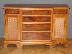 A reproduction breakfront yew veneer credenza, fitted six drawers and a pair of grilled cupboard