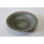 A Celadon ground pottery charger with incised decoration from The Royal Nanhai Cargo, diameter 30cm