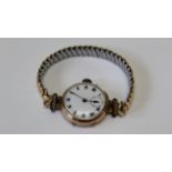 A 9ct gold cased ladies wristwatch on a gilded Gemex USA stretching bracelet. With a white enamel