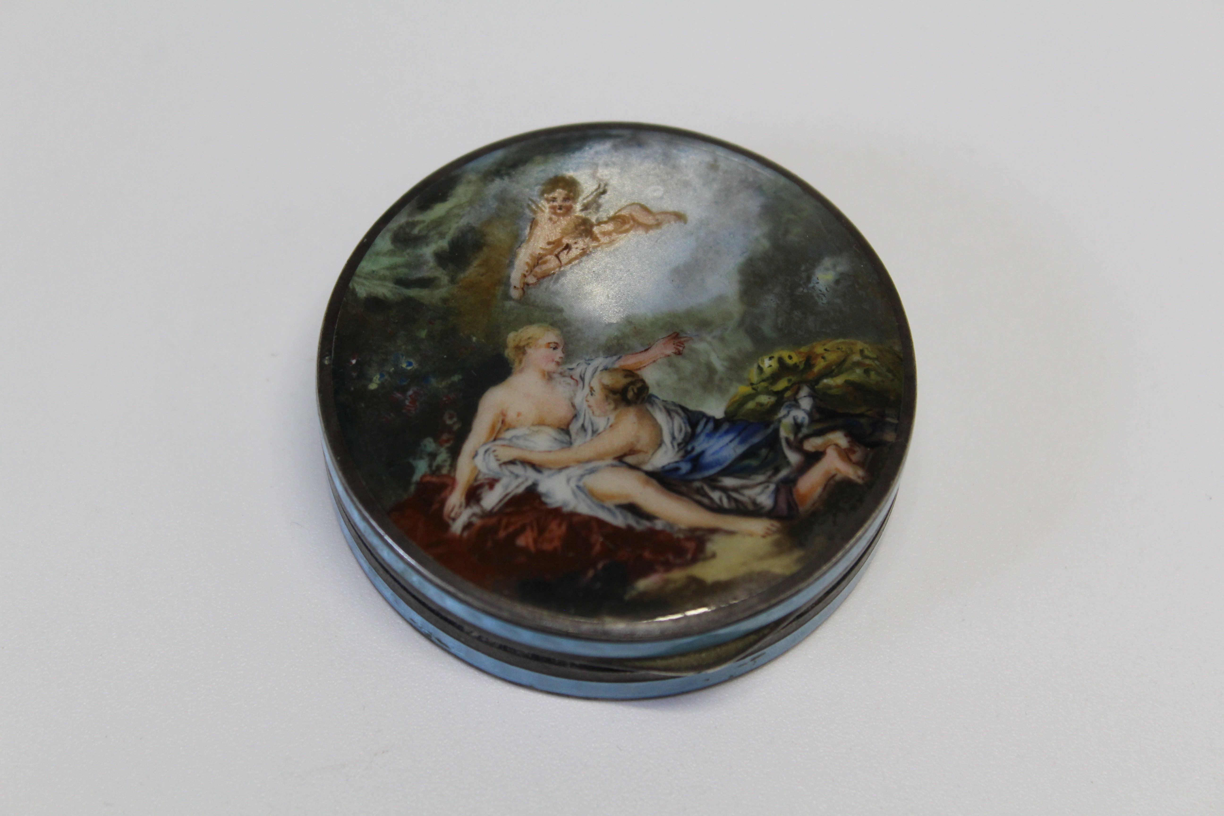 A circa 1920's silver gilt and enamel compact of disc shape. The hinged cover decorated with an