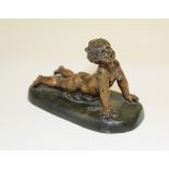 A small 20th century hollow cast bronze of a child lying prone, on an indistinctly signed