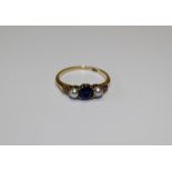 A sapphire, split pearl and diamond dress ring. Set with a round mixed cut sapphire, measuring