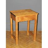 A mid 20th century beech school desk, with covered flush brass inkwell and rising top, raised on