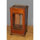 A late Victorian walnut music cabinet, with three quarter gallery top and glazed door raised on