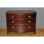 An early 19th century mahogany and crossbanded bowfront chest fitted with two short and two long
