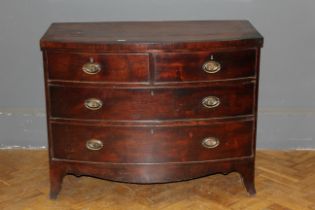An early 19th century mahogany and crossbanded bowfront chest fitted with two short and two long