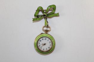 An Edwardian green enamel gilt silver ladies brooch watch. The ornate watch is suspended from a gilt