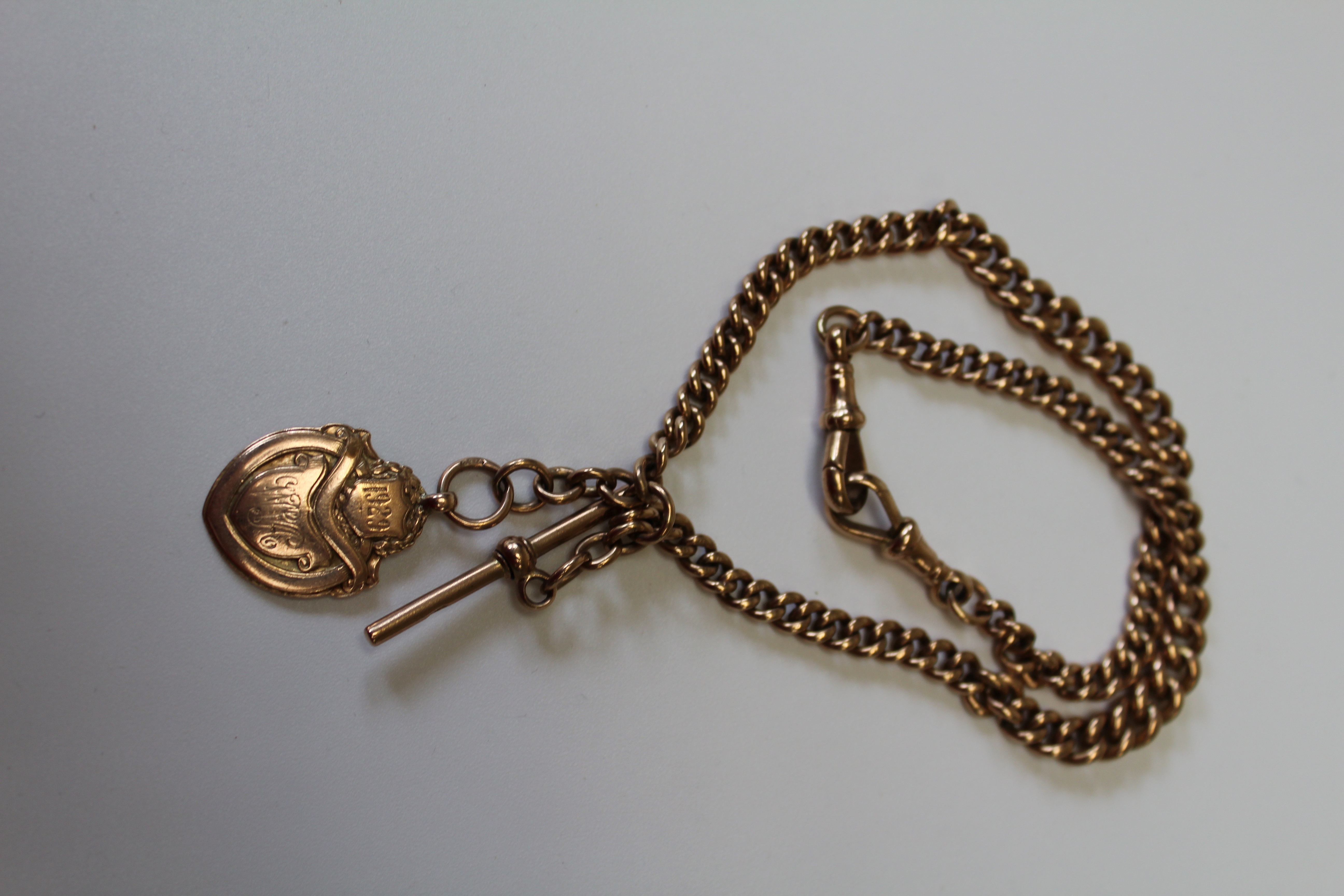A 9ct gold double Albert watch chain, with two fob clips, t-bar and an engraved shield medallion
