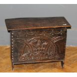 A small oak panel coffer in the 17th century style having a carved front panel, width 67cm