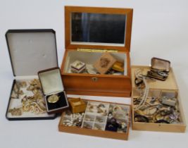 A box of costume jewellery with a variety of earrings, brooches and rings