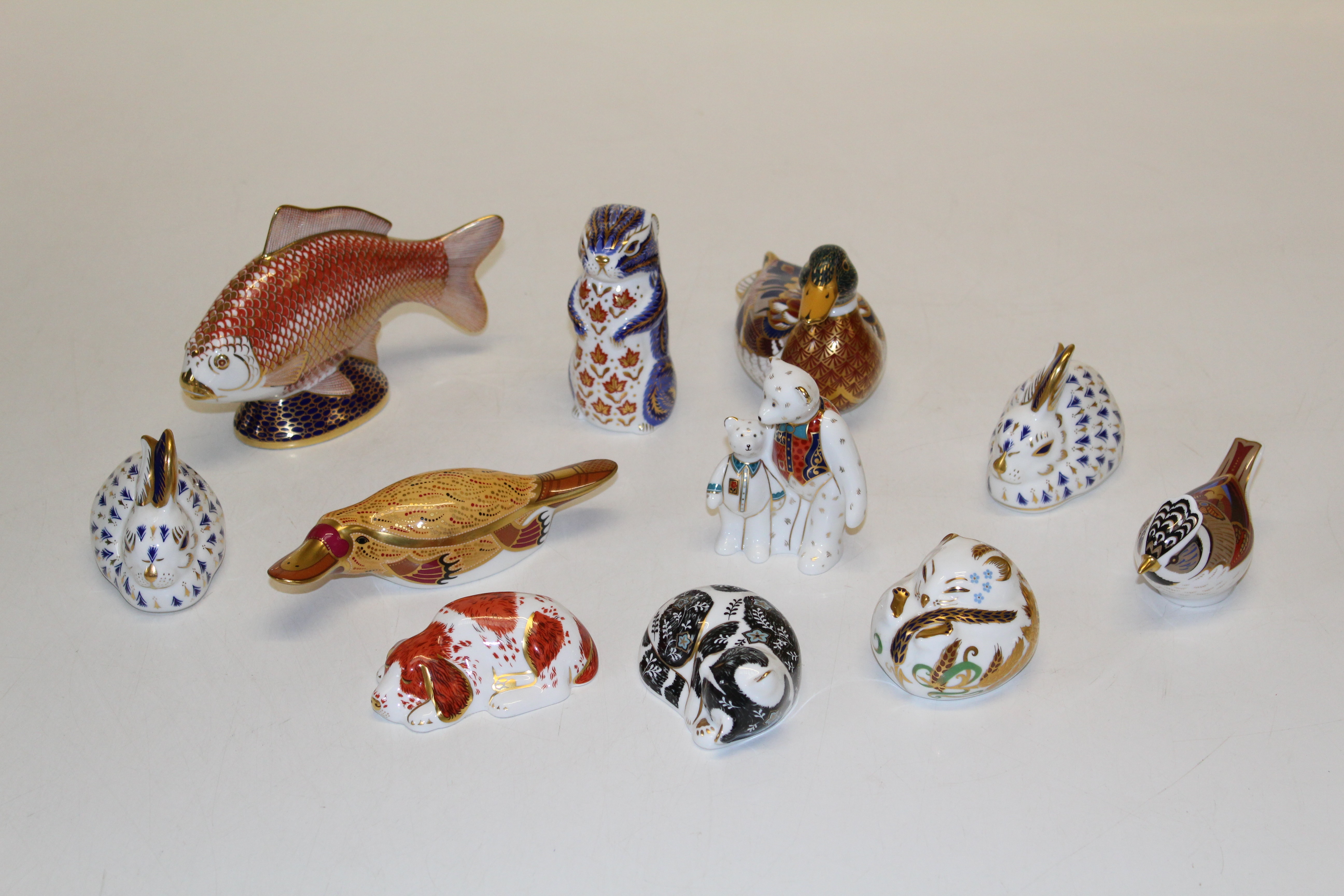 A collection of Royal Crown Derby paperweights, eight with gold stoppers, platypus, chipmunk,