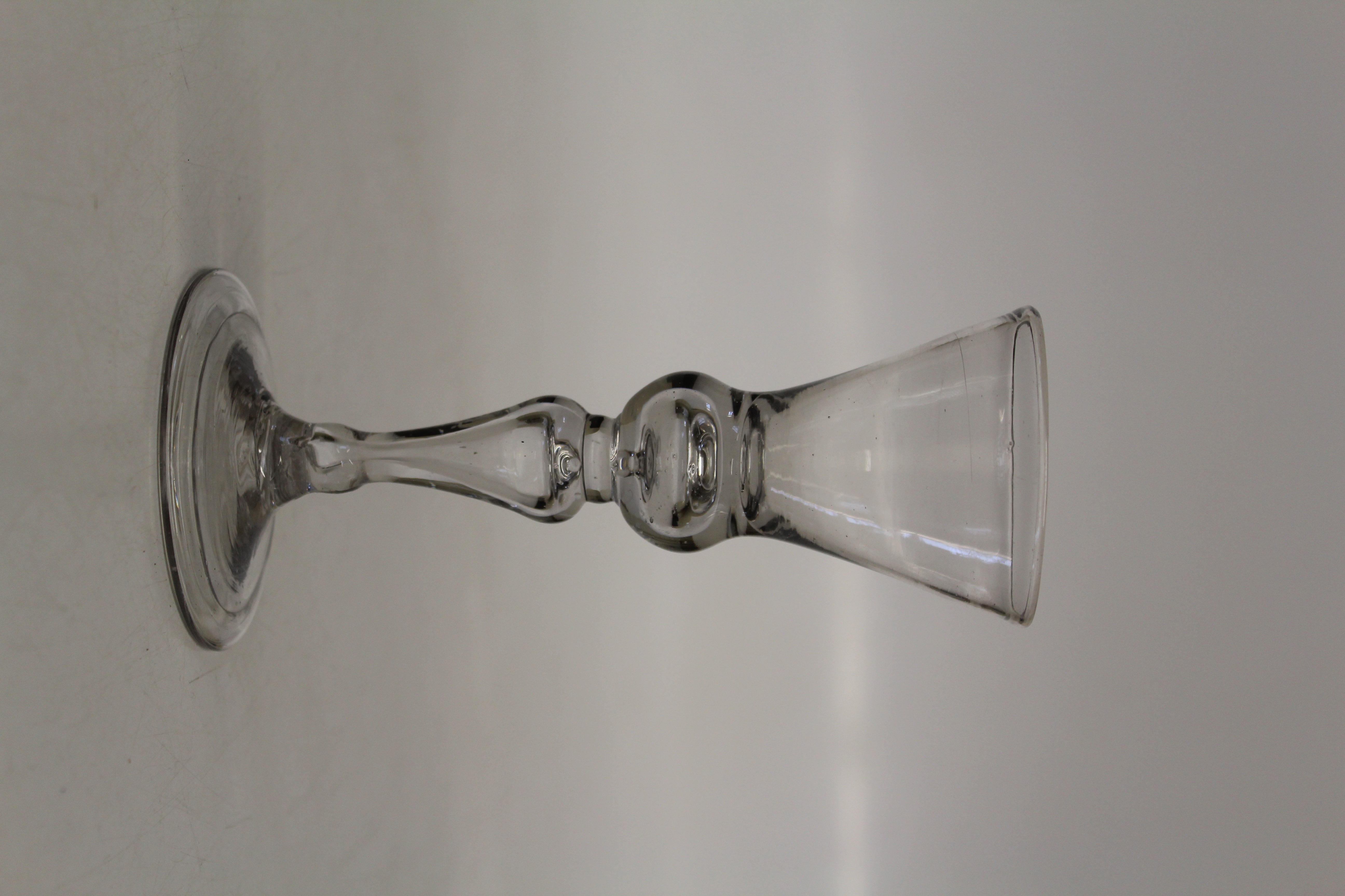 A George III wine glass, the conical bowl over bubble included knop stem on a folding spreading