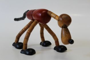 A Brio articulated figure, Pluto, with red painted body, black feet and tail, circa 1930s, ears