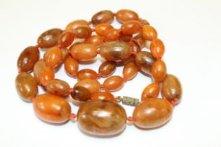 An early 20th century egg yolk amber graduated bead necklace. Each bead has distinct and natural