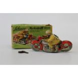 A boxed Schuco Motodrill 1006 tinplate clockwork motorcycle, rider number 6 with red motorcycle,