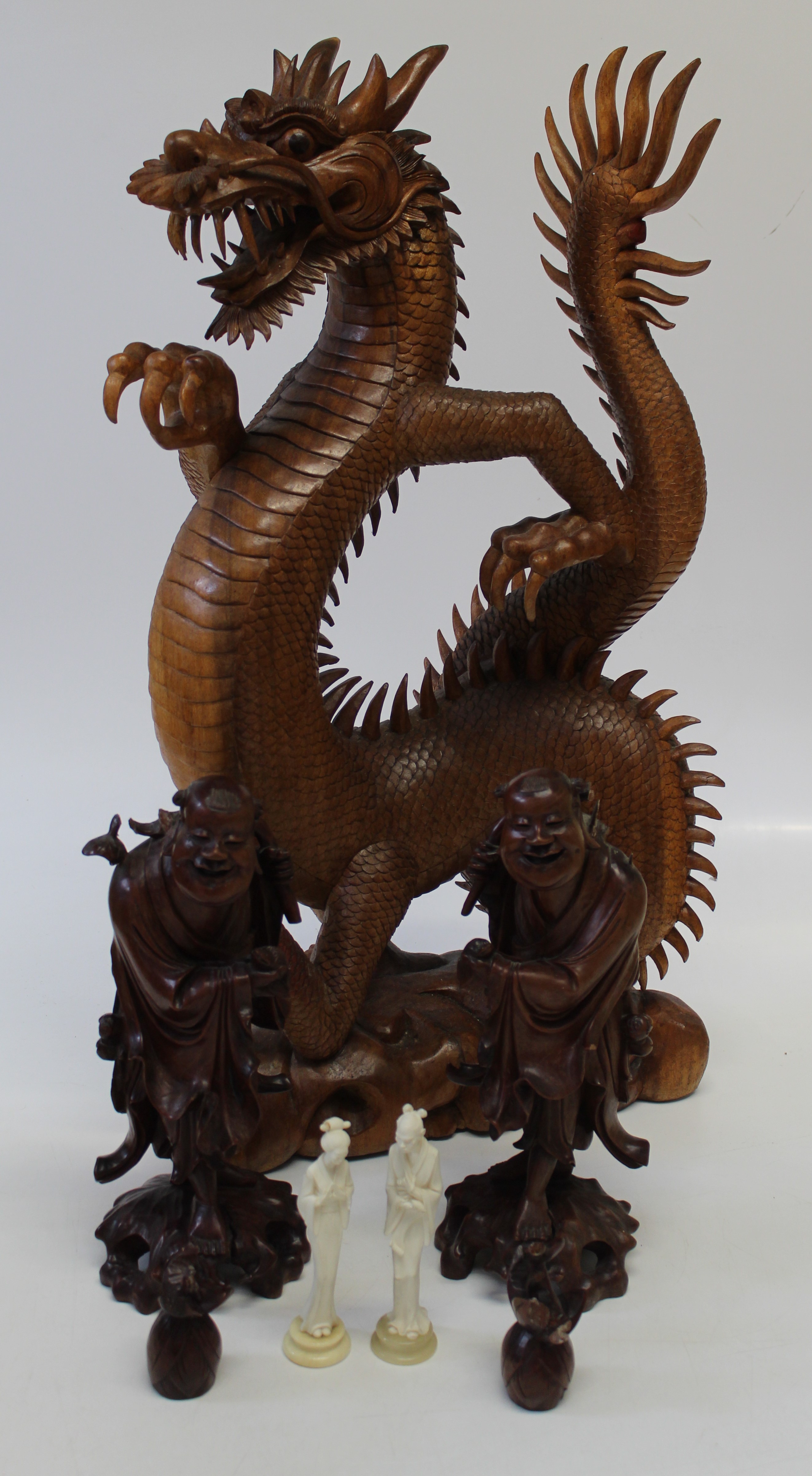 A pair of Chinese carved figures of deities, laughing holding a rat, formerly fitted as a lamp base,