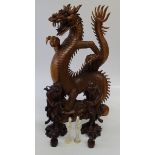 A pair of Chinese carved figures of deities, laughing holding a rat, formerly fitted as a lamp base,