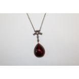 A garnet, cultured pearl and rose cut diamond set pendant. In closed back yellow precious metal