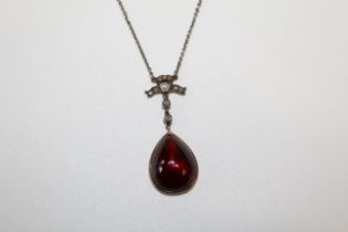 A garnet, cultured pearl and rose cut diamond set pendant. In closed back yellow precious metal