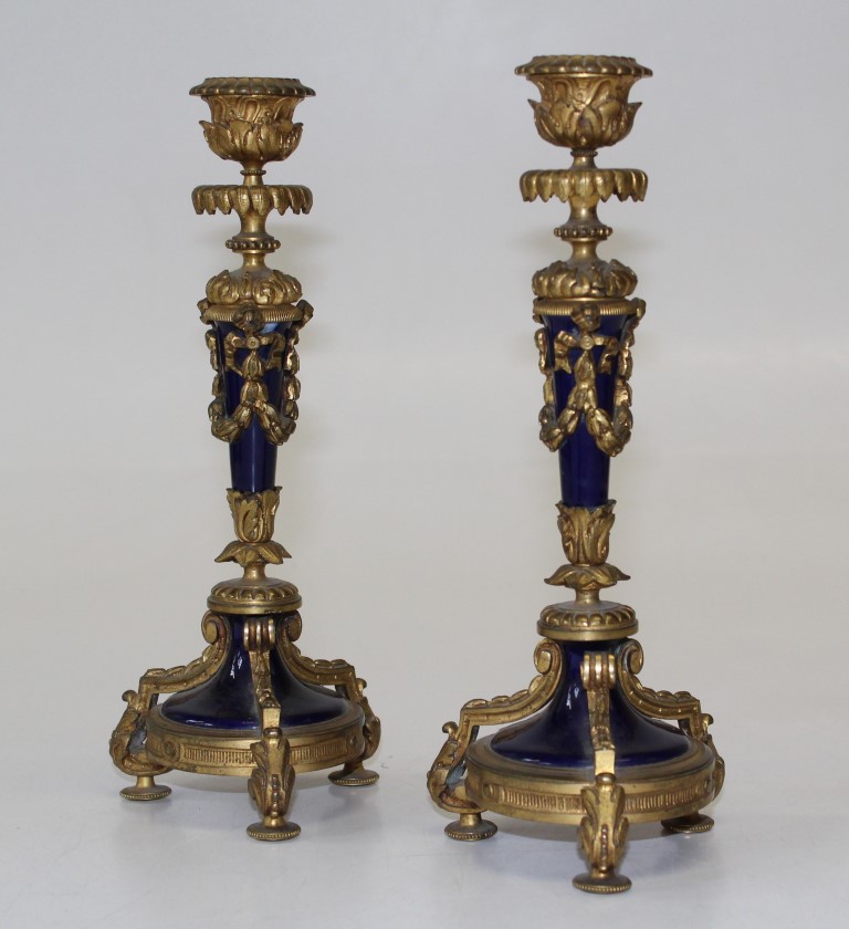 A pair of Louis XVI style gilt bronze and blue enamel candlesticks, decorated with neo classical