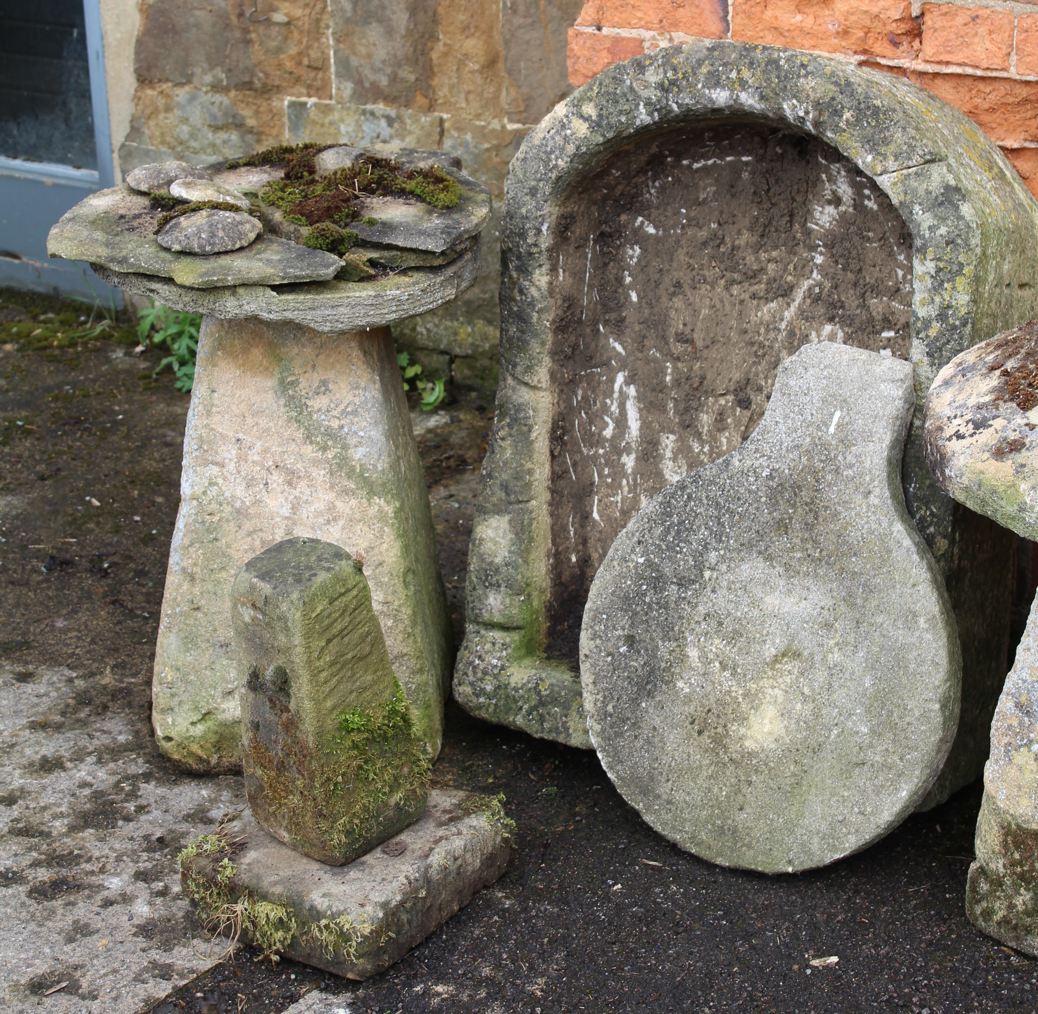 A large stone garden basin, together with a staddle stone base, another smaller, a square stone