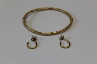 A twisted yellow metal hinged bangle marked 750 with Italian goldsmiths marks, 4.66 grams