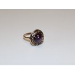 A star sapphire cocktail ring. Set with a purple star sapphire, in claw setting above an openwork