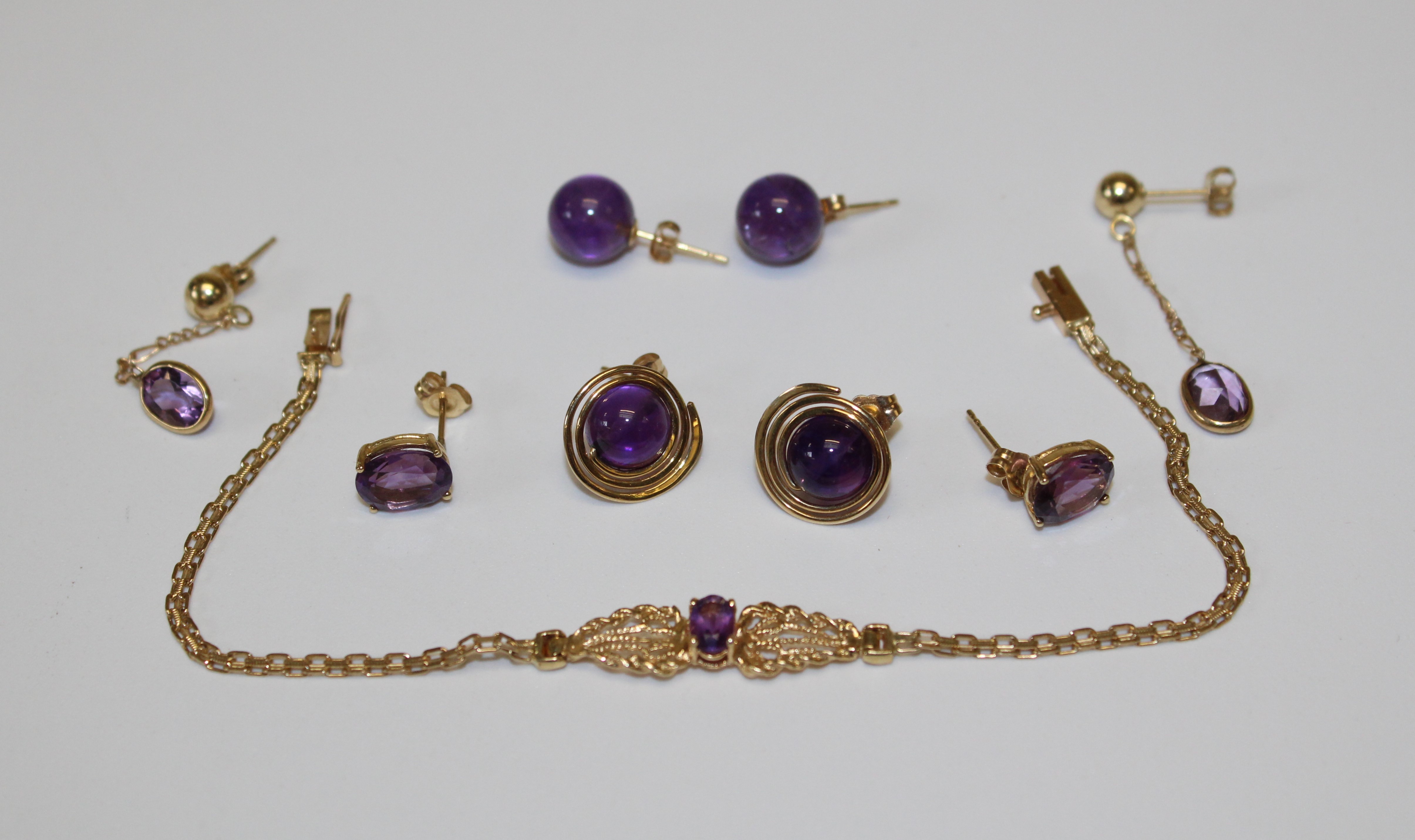 A collection of Amethyst and 14k gold jewellery comprising a bracelet set with an oval amethyst (