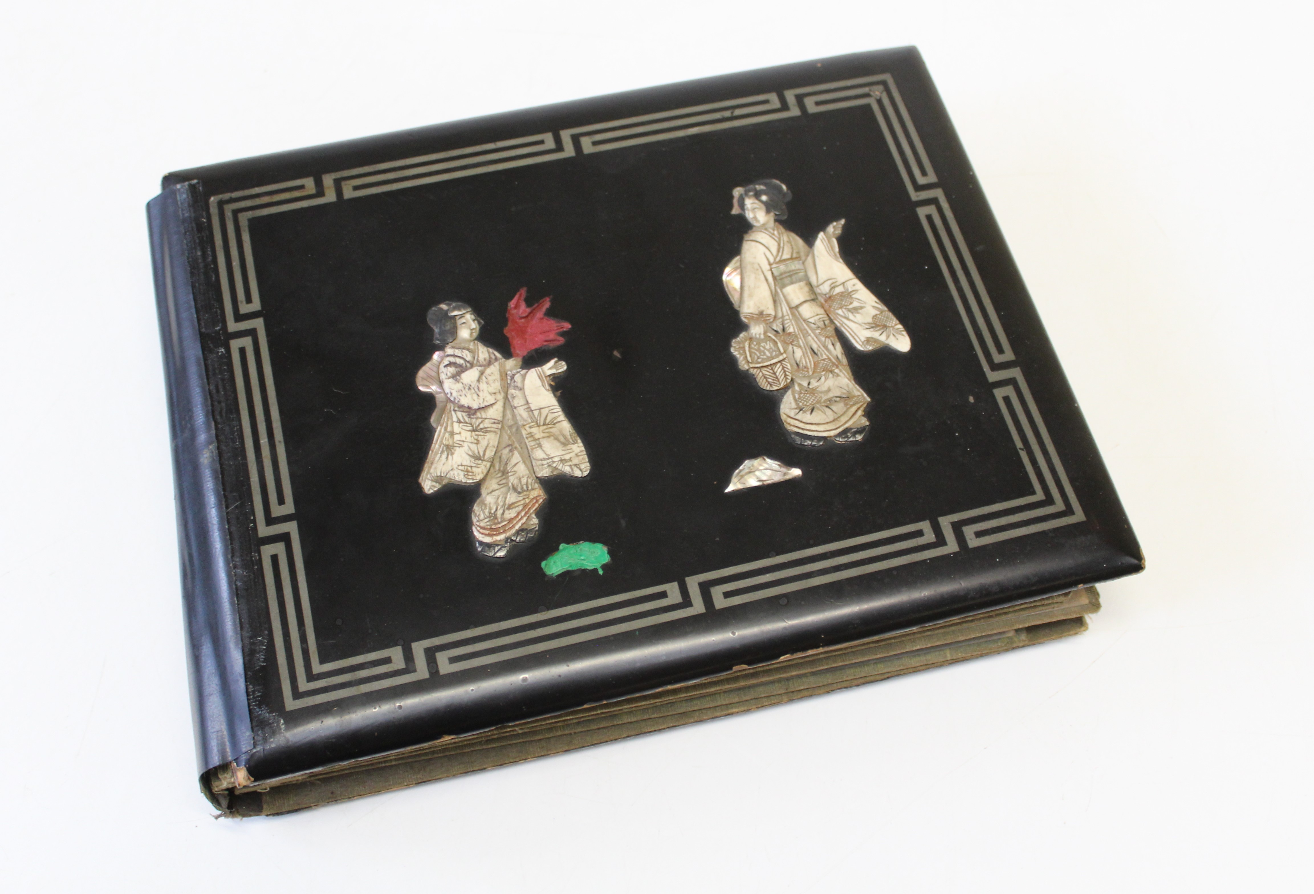 An early 20th century Japanese black lacquer postcard album, containing approximately seventy early/