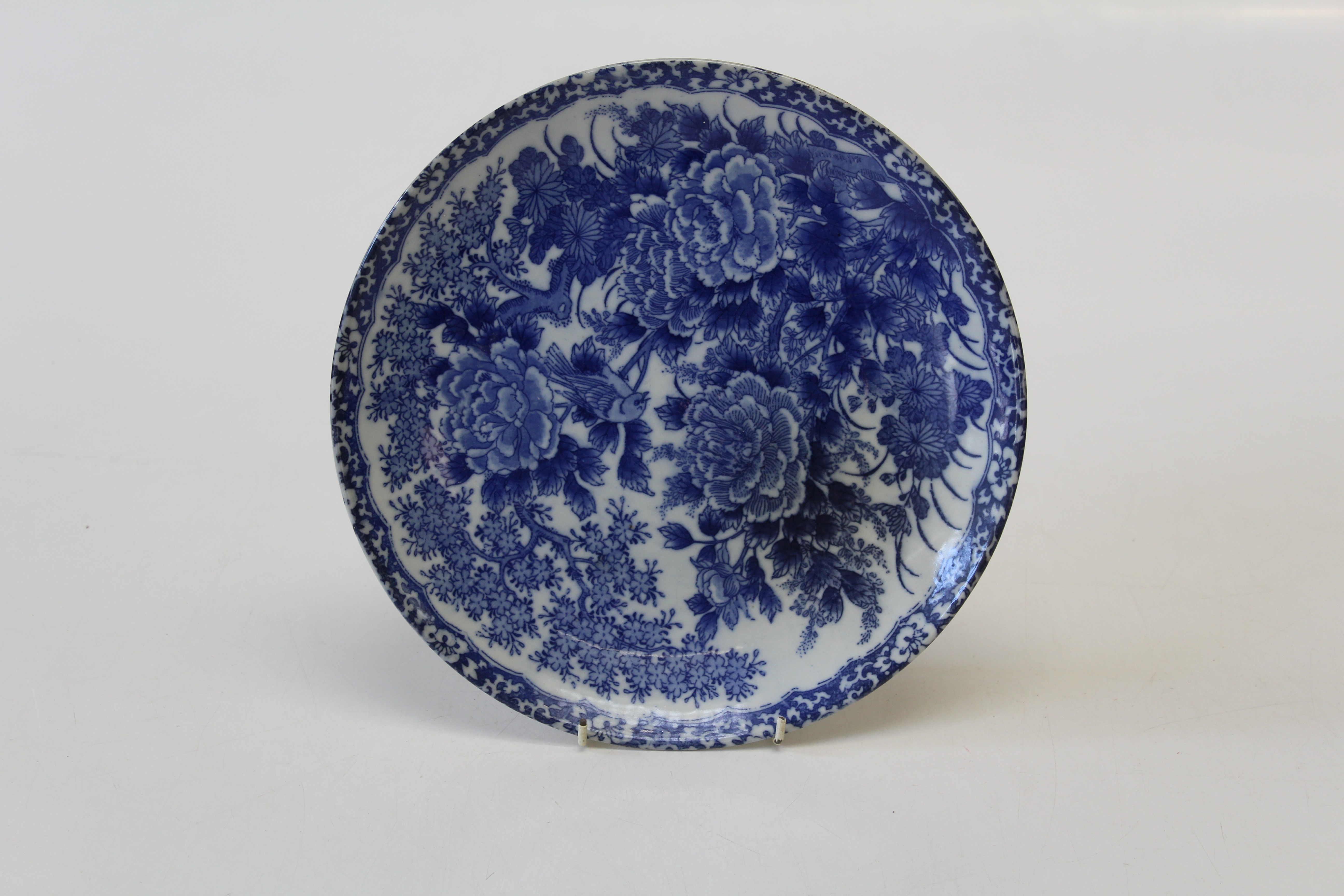 A late 19th century Japanese porcelain blue and white dish, decorated with a perched songbird and