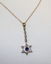 An Edwardian style six pointed star pendant set with a central round mixed cut sapphire, and adorned