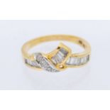 A diamond and 18ct gold ing, comprising channel set tapered baguette diamonds and claw set round