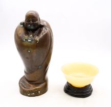A 20th century or modern mutton fat jade type bowl on wooden stand, along with a Japanese God with