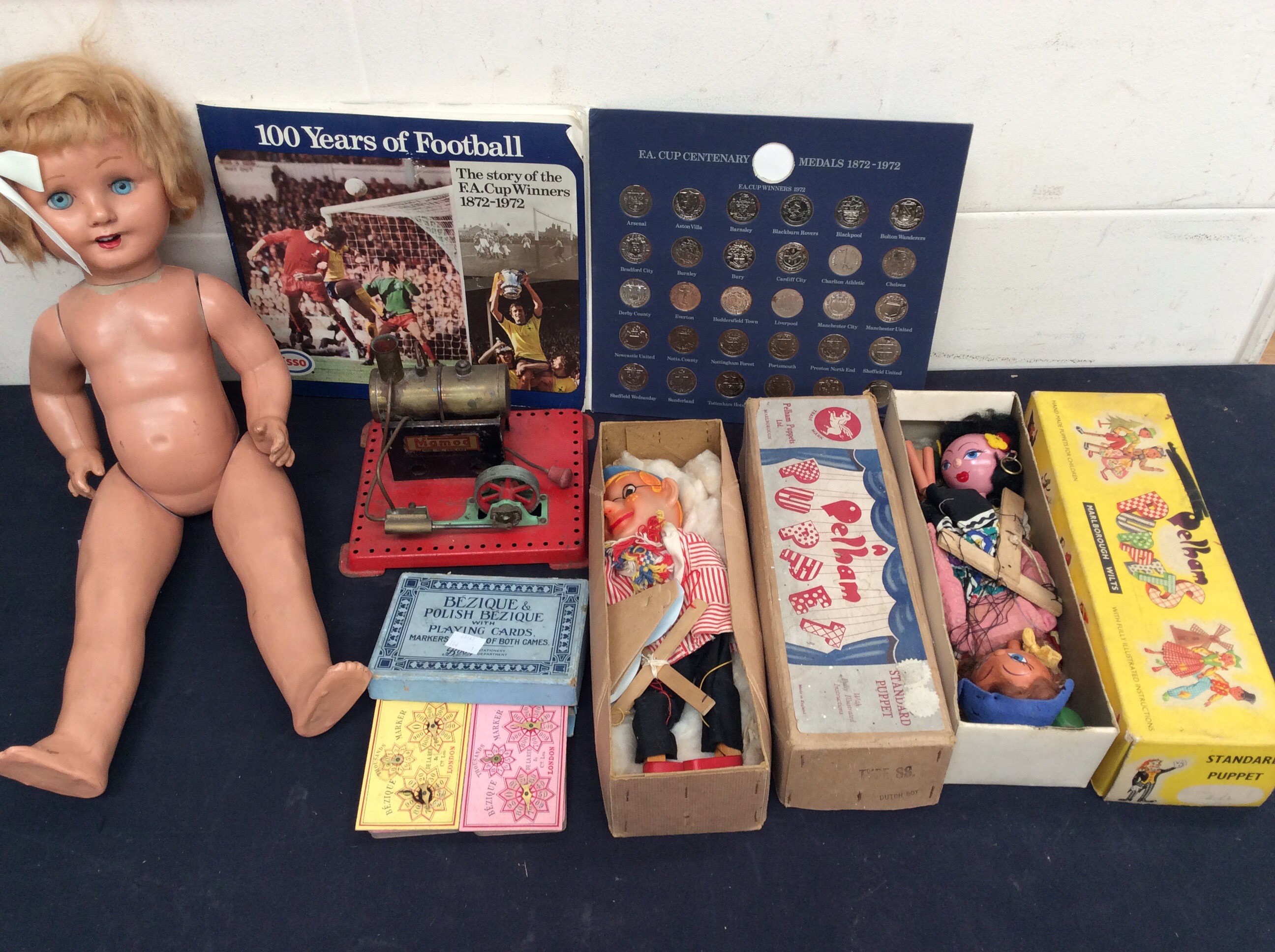 Three Pelham boxed puppets, Mamod steam engine doll and card game.