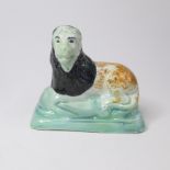 A Small Staffordshire Prattware model of a lion recumbent on an oblong base Circa; 1800 Size;