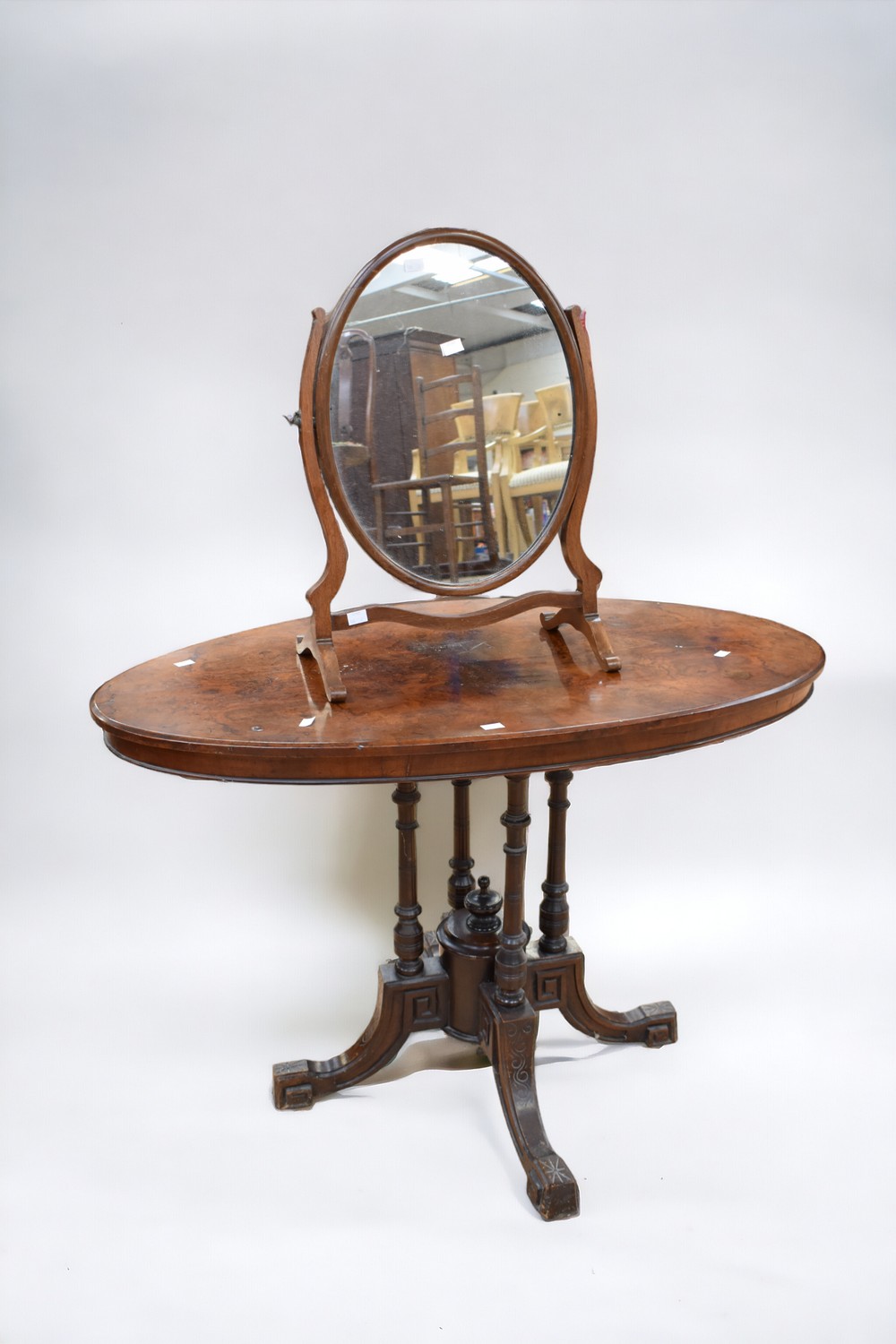 A Victorian oval tilt top occasional burr walnut table on four splayed legs (bubbling to table