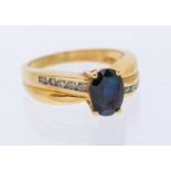 A sapphire and diamond 18ct gold cross over ring, set with an oval mixed cut sapphire approx