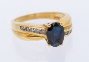 A sapphire and diamond 18ct gold cross over ring, set with an oval mixed cut sapphire approx