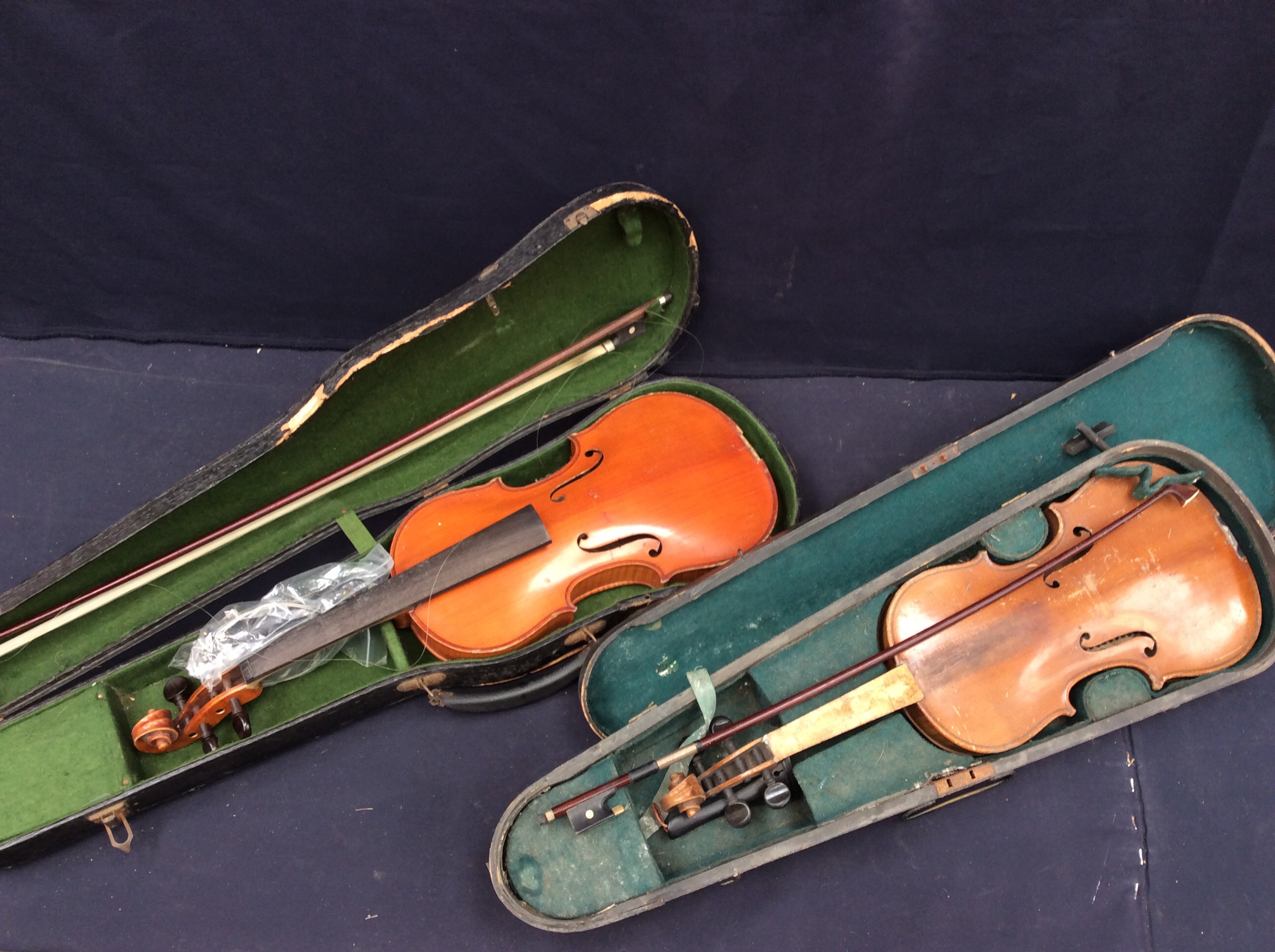 Two early 20th Century violins in cases with bows.