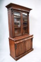 A Victorian glazed display cabinet of two glazed doors above a single drawer and two further