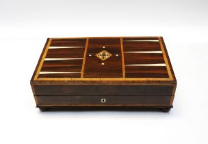 A 19th century veneered games box with inlay, on bun feet and with contents intact.