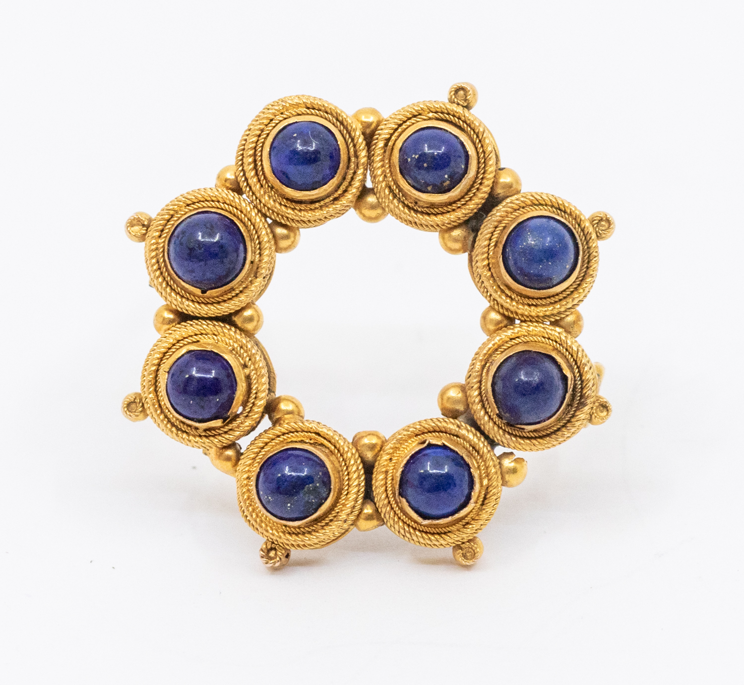 An early 20th century lapis lazuli and gold brooch, comprising a circular design set with eight