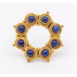 An early 20th century lapis lazuli and gold brooch, comprising a circular design set with eight