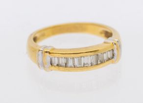 A diamond and 18ct gold ring, comprising a row of channel set baguette cut diamonds, white gold