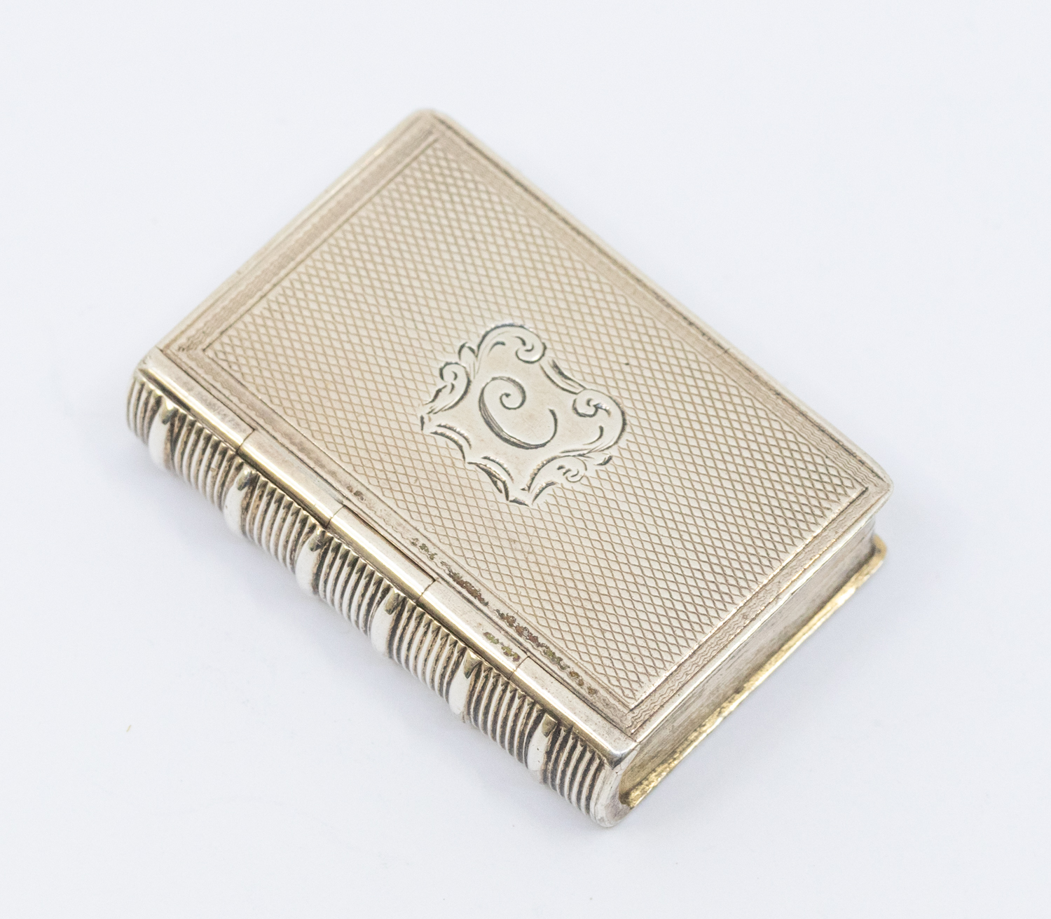 A Victorian silver book shaped vinaigrette, the cover with engraved initial, opening to reveal