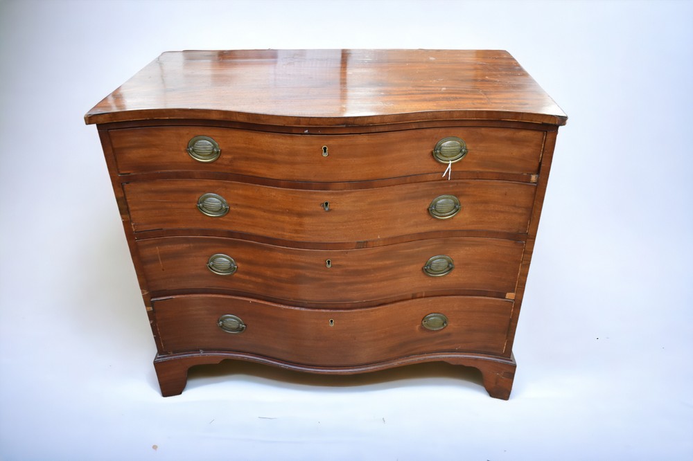 A Georgian serpentine-fronted chest of drawers in mahogany, with condition issues