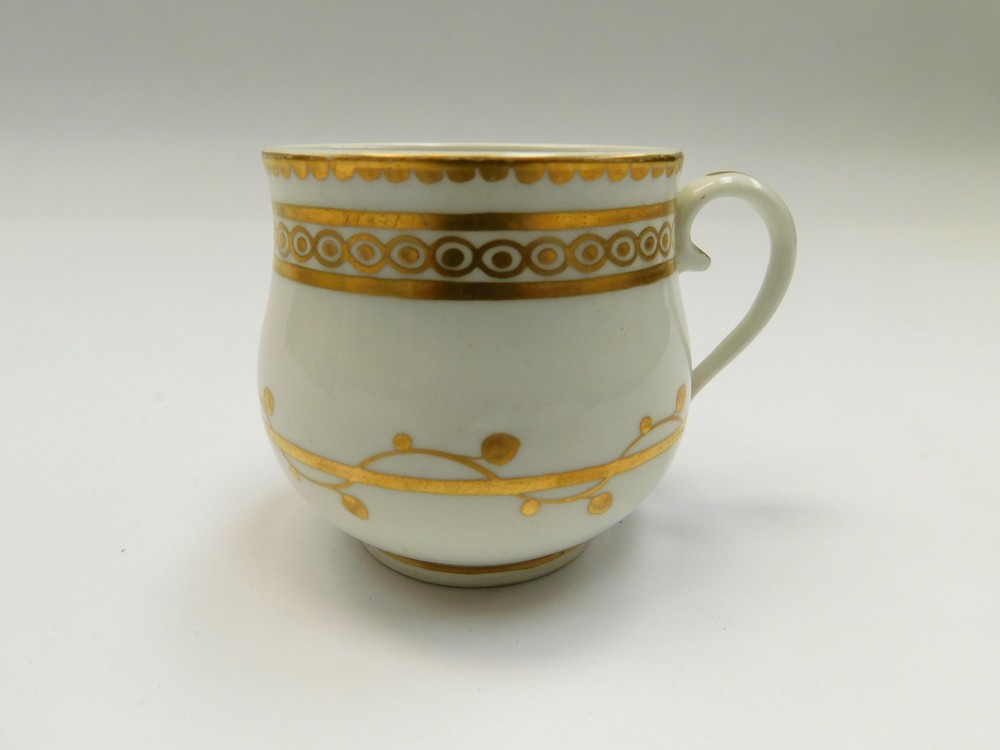 A Derby white and gilt custard cup, decorated with gilt swag and bands Circa 1790. Puce mark